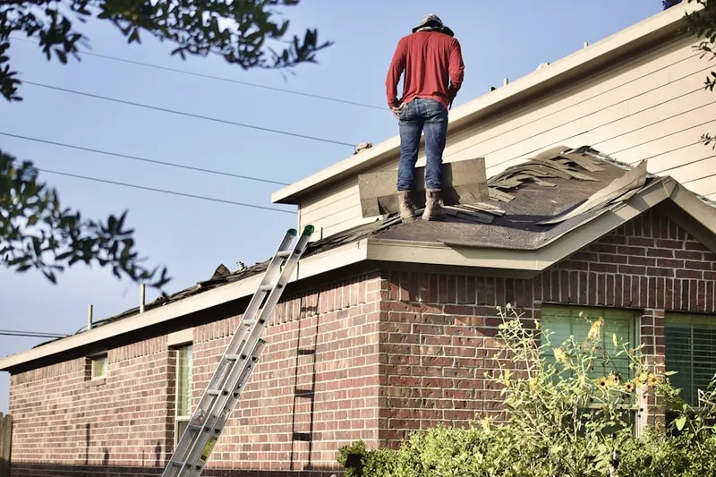 Professional roofer working on a residential roof in New Design Acres